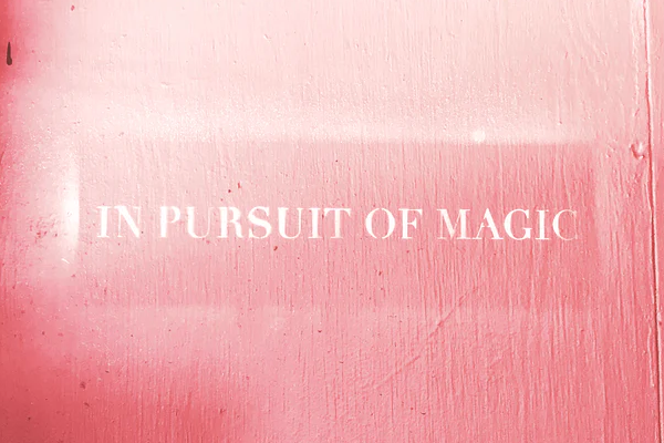 red wall with the words in pursuit of magic