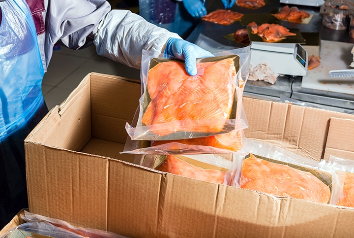 Worker handling packaged salmon