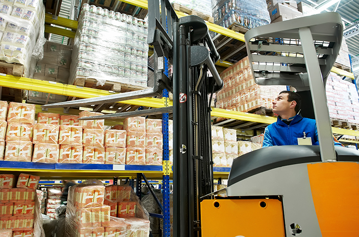 Worker looking at shelved product from forklift