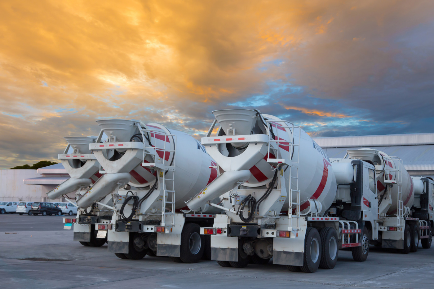 multiple cement mixer trucks parked in a lot