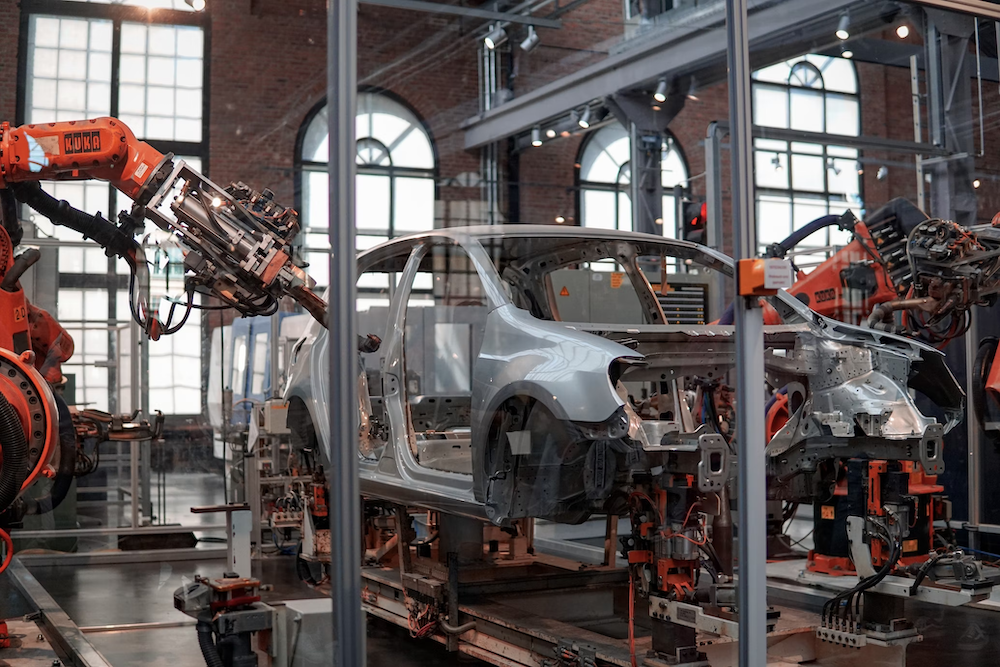 car being assembled by robot arms in a factory